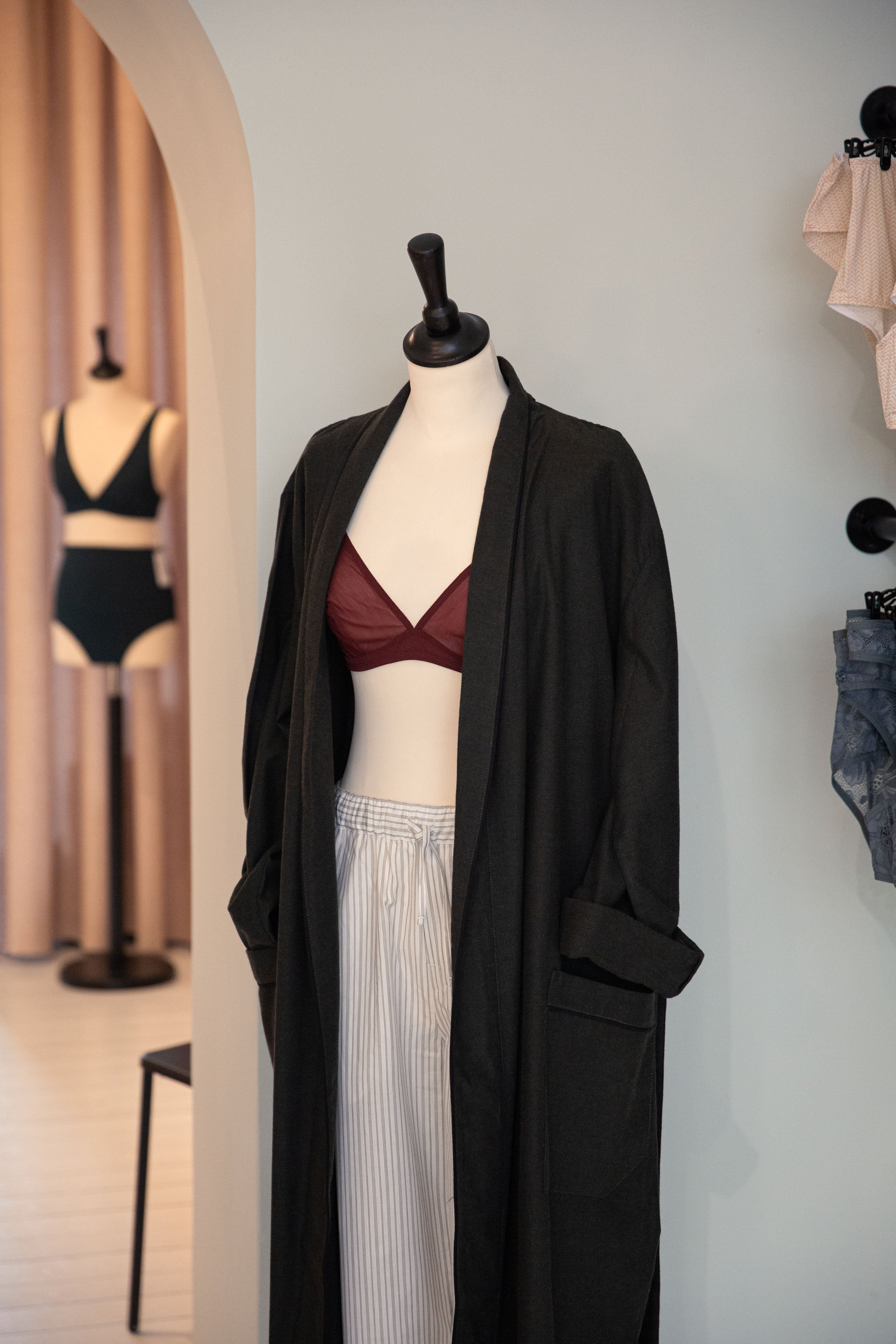 Schaufensterpuppe mit schwarzer Robe und rotem BH